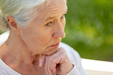 Image showing sad senior woman sitting on bench at summer park