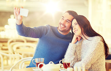 Image showing couple taking smartphone selfie at cafe restaurant