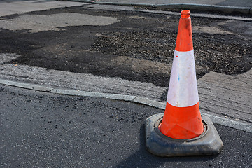 Image showing Bright orange and white traffic cone on a sidewalk