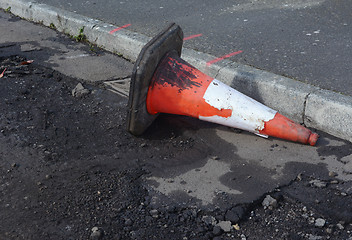 Image showing Damaged traffic cone in gutter, road undergoing repairs