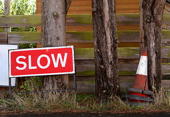 Image showing SLOW traffic sign with broken orange and white traffic cones
