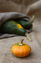 Image showing Disc-shaped ornamental gourd and large green gourds on hessian