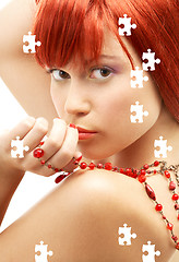 Image showing puzzle of redhead with red beads looking over shoulder