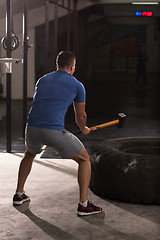 Image showing man workout with hammer and tractor tire