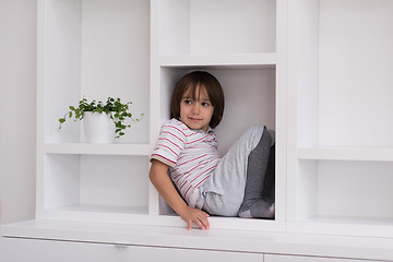 Image showing young boy posing on a shelf