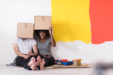 Image showing young multiethnic couple playing with cardboard boxes