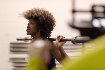 Image showing black woman lifting empty bar