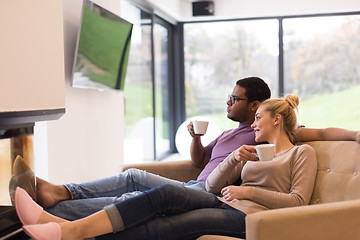 Image showing Young multiethnic couple  in front of fireplace