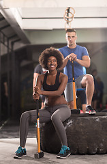 Image showing multiethnic couple after workout with hammer