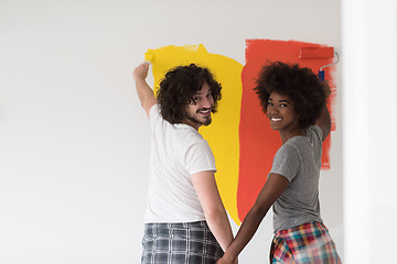 Image showing multiethnic couple painting interior wall