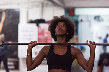 Image showing black woman lifting empty bar