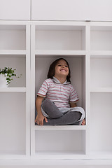 Image showing young boy posing on a shelf