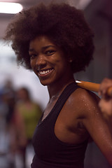 Image showing black woman lifting empty bar