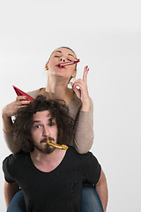 Image showing couple in party hats blowing in whistle