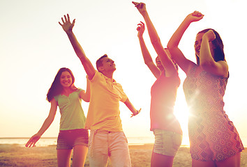 Image showing smiling friends dancing on summer beach