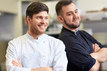 Image showing happy smiling chef and cook at restaurant kitchen