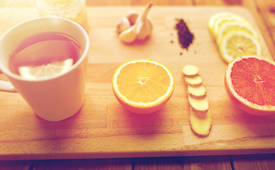 Image showing ginger tea with honey, citrus and garlic on wood