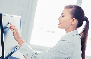 Image showing smiling businesswoman with touchscreen in office