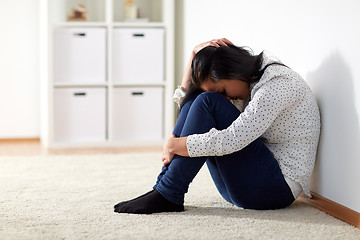 Image showing unhappy woman crying on floor at home