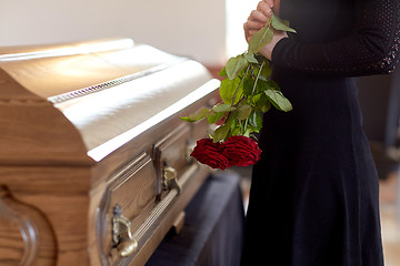 Image showing woman with red roses and coffin at funeral