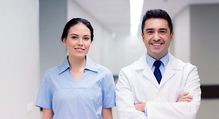 Image showing smiling doctor in white coat and nurse at hospital