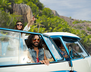 Image showing happy hippie friends in minivan car on island