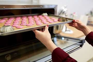 Image showing chef with macarons on oven tray at confectionery