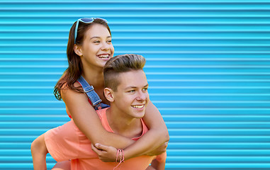 Image showing happy teenage couple having fun over blue