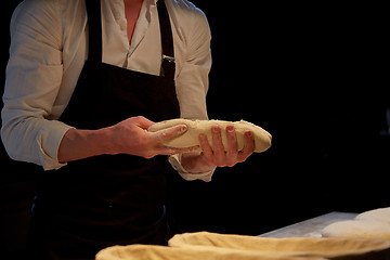 Image showing baker with dough rising in baskets at bakery