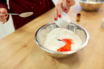 Image showing chef hands adding food color into bowl with flour