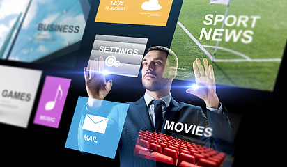 Image showing businessman with applications on virtual screen