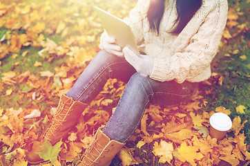 Image showing woman with tablet pc and coffee in autumn park