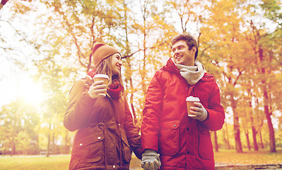 Image showing happy couple with coffee walking in autumn park