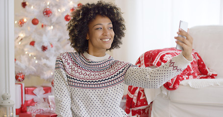 Image showing Happy young woman posing for a Christmas selfie
