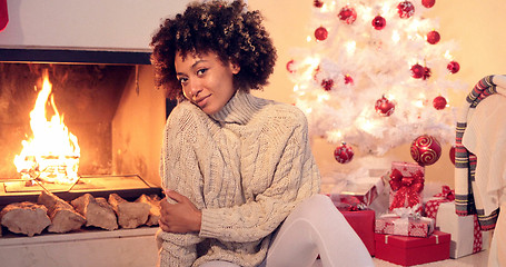 Image showing Beautiful black woman seated beside white tree