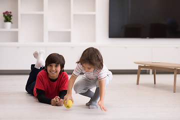 Image showing boys having fun with an apple on the floor