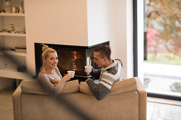 Image showing Young couple  in front of fireplace