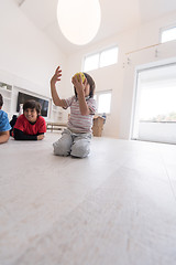 Image showing boys having fun with an apple on the floor