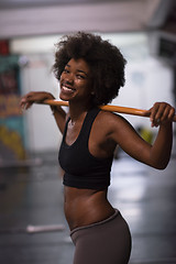 Image showing black woman lifting empty bar