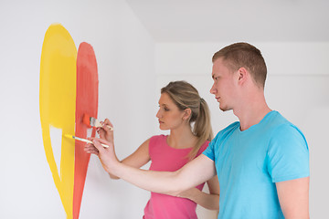 Image showing couple are painting a heart on the wall