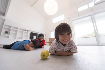 Image showing boys having fun with an apple on the floor