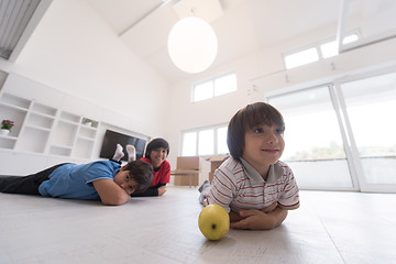 Image showing boys having fun with an apple on the floor