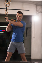 Image showing man workout with hammer and tractor tire