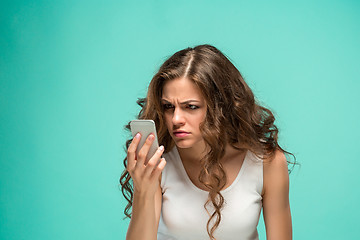 Image showing The portrait of disgusted woman with mobile phone