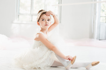 Image showing The little balerina in white tutu in class at the ballet school