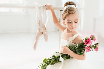 Image showing Little ballerina girl in a tutu. Adorable child dancing classical ballet in a white studio.