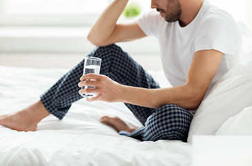 Image showing man in bed with glass of water at home