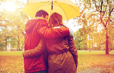 Image showing happy couple with umbrella walking in autumn park