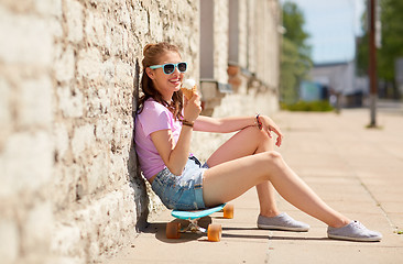 Image showing happy teenage girl with longboard eating ice cream