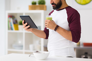 Image showing man with tablet pc having breakfast at home